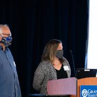 Co-mentors wearing masks and introducing scholar.